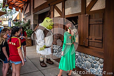 People watch as Fiona, Shrek and donkey talk. at Universal Studios Editorial Stock Photo