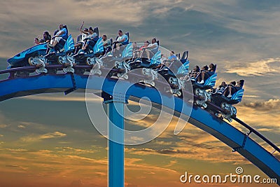 People enjoing amazing Mako roller coaster at Seaworld on beatiful sunset sky background. Editorial Stock Photo