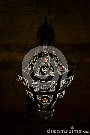 Ornamental oriental arabic metal lamp with colored stones. Dark brick background Stock Photo