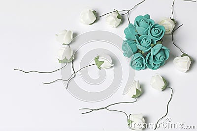 Ornaments for celebrations. A bouquet of artificial flowers. Rose beige and emerald colors. On a white background. Stock Photo