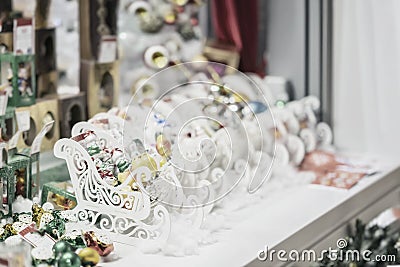 Ornaments, Christmas balls and white wooden sledges. Sale of Christmas decorations. Abstract light blurred holiday Stock Photo