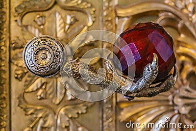 Ornate door handle with a stylized eagle foot and a red crystal in Winter Palace Hermitage museum in Saint Petersburg, Russia Editorial Stock Photo