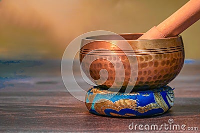 Ornate, hand-hammered Tibetan bell on a golden background Stock Photo