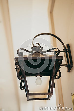 an ornate lamp next to a white wall in the hallway Stock Photo