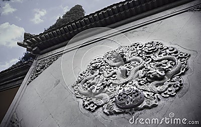 Ornate low relief sculpture of dragon on wall. Stock Photo