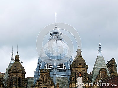 The ornate roof dome and towers of leeds city market in west yorkshire against a grey cloudy sky Stock Photo