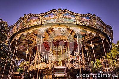 Ornate traditional carousel fairground ride on a sunny, golden morning in Montmartre, Paris, France Editorial Stock Photo