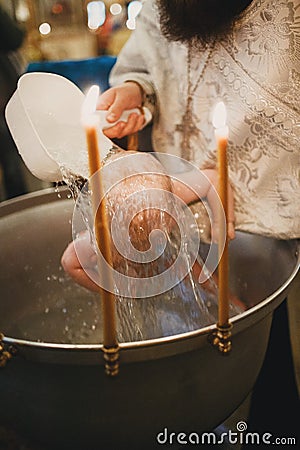 Orthodox Christian priest and little child in the church. Epiphany ceremony rite and font. Stock Photo