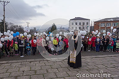 Orthodox priest and people with white balloons on the day of mourning for those killed in a fire in Kemerovo Editorial Stock Photo