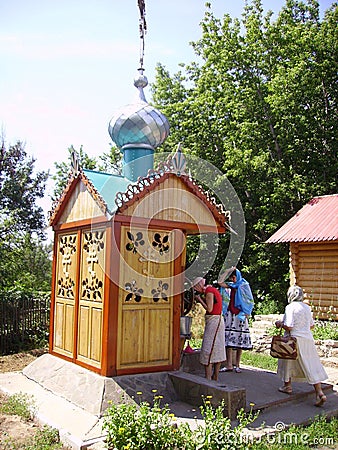 Orthodox women pilgrims collect water in a well with consecrated water. Editorial Stock Photo