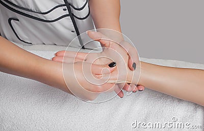 An orthopedic doctor does relaxing massage of the hand and arm of the patient after in the clinic. Cosmetology and massage concept Stock Photo