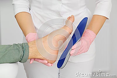 Orthopedic insoles. Fitting orthotic insoles. Flatfoot treatment. Podiatry clinic Stock Photo