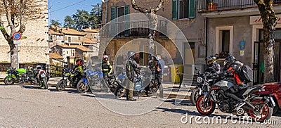 Masked and unmasked traveling bikers who stop to eat in Italian Borgo Orvinio during second wave of coronavirus Covid19, Italy Editorial Stock Photo