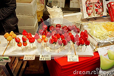 Strawberry and Cherry in wooden sticks with Japanese name and price labels. Editorial Stock Photo