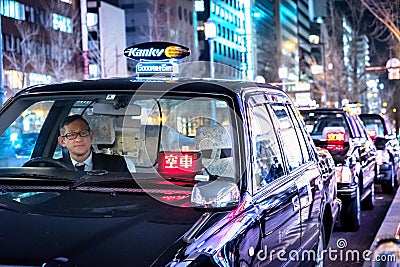 Taxi driver waits for passengers to board at a taxi stand Editorial Stock Photo