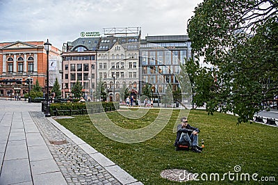 Oslo, Norway-August 1, 2013: a Man rests after work on the Eidsvoll Plass lawn Eidsvoll square is a square and Park located West Editorial Stock Photo