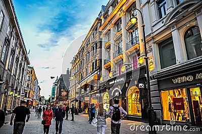 OSLO, NORWAY: People walking around in Karl Johans Gate, the famous street of Oslo in the evening Editorial Stock Photo