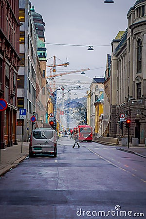 OSLO, NORWAY - MARCH, 26, 2018: Outdoor view of people walking and car close to a traffic lights in the streets of Oslo Editorial Stock Photo