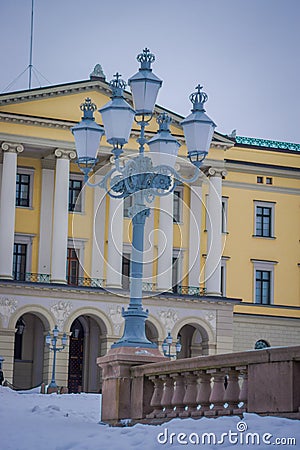 OSLO, NORWAY - MARCH, 26, 2018: Outdoor view of public park lantern with a Royal Palace behind in Oslo Editorial Stock Photo