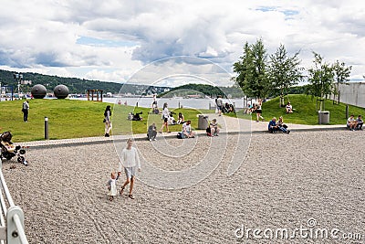 Oslo people on harbour beach Aker Brygge Editorial Stock Photo