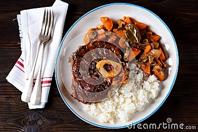 Osso buco beef stew with boiled rice in tomato sauce with onions, carrots, celery, garlic, rosemary and laurel leaves. Stock Photo