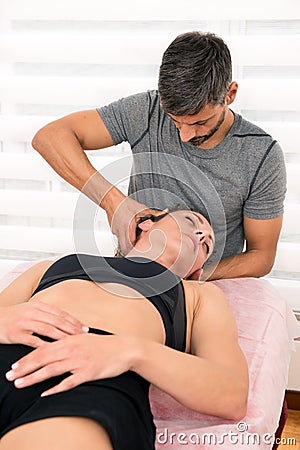 Osteopath performing cervical trust therapy Stock Photo