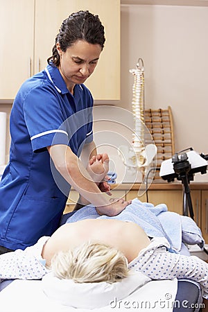 Osteopath treating female client Stock Photo