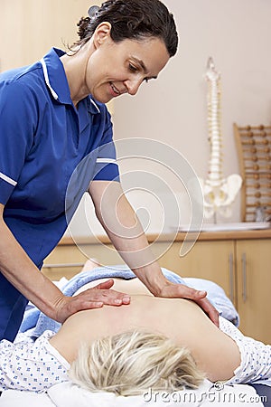 Osteopath treating female client Stock Photo