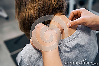 Osteopath in uniform edits cervical spine vertebrae of young female patient on massage bed closeup Stock Photo