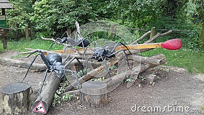 Ostrava, Czech - 07 05 2021: Three giant statues of black forest ants and a match with red tip over a pile of trunks in ZOO Editorial Stock Photo