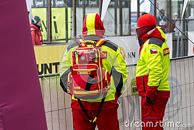Ostrava, Czechia - 02.04.2023: Two male security medics in bright green reflective vests overlooking run race Editorial Stock Photo