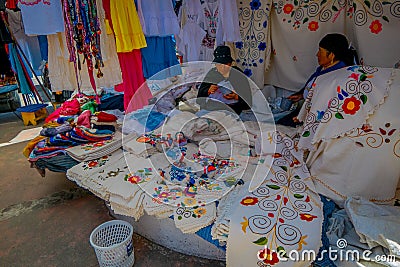 OTAVALO, ECUADOR, NOVEMBER 06, 2018: Unidentified women eating the lunch and selling the typical andean fabrics sold on Editorial Stock Photo