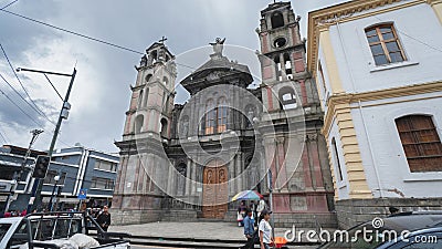 People walking in front of the El Jordan Church in the center of the city of Otavalo during a cloudy day Editorial Stock Photo