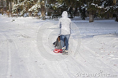 Other walking on an empty, snowy street driving modern sledge Editorial Stock Photo