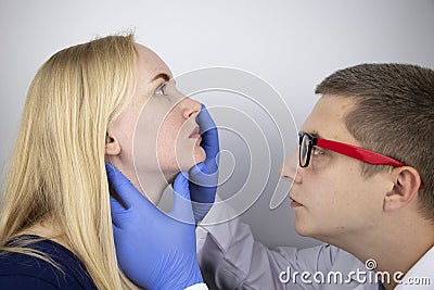 The otolaryngologist examines the girl`s nasal passages. Painful sensations in the nose, polyps, adenoids and shortness of breath Stock Photo