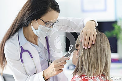 Otorhinolaryngologist examining patients sore ear with otoscope in clinic Stock Photo