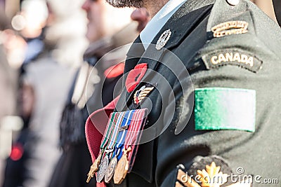 Details of the uniform of Canadian Army ground forces with the Remembrance poppy and medals, seen from behind Editorial Stock Photo