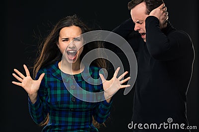 ouple having conflict, bad relationships. Angry fury woman screaming man closing his ears. Stock Photo