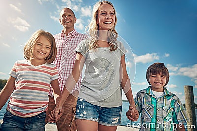 Our family is just the perfect mixture of love. a young family on a pier while out by the lake. Stock Photo