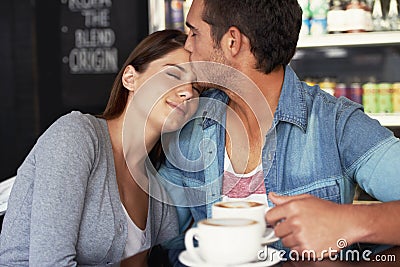 Our love knows no boundries. a young couple kissing in a cafe. Stock Photo