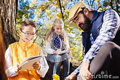 Joyful nice children looking into their notes Stock Photo