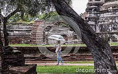 Ourist woman holding silver umbrella and walking at Wat Ratchaburana Editorial Stock Photo