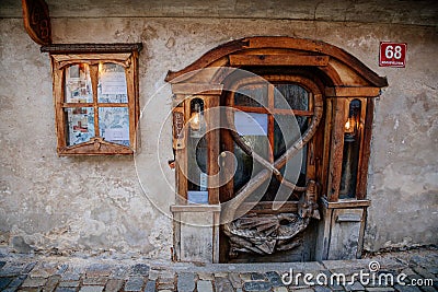 Ouroboros. Dragon biting its own tail, carved wooden door. Cesky Krumlov, South Bohemia, Czech Republic Editorial Stock Photo