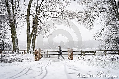 Single lone anonymous commuter walking to work during winter blizzard and heavy snowstorm wrapped up warm during icy storm Stock Photo