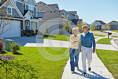 Out for a leisurely afternoon stroll. a happy senior couple waking around their neighborhood together. Stock Photo