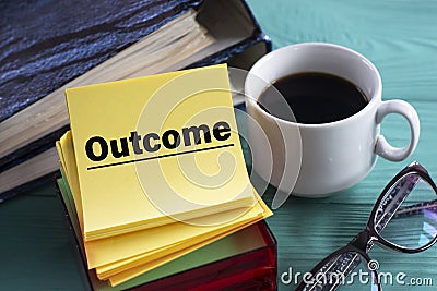 OUTCOME - word on yellow note sheets on green background with a cup of coffee, glasses and folders Stock Photo