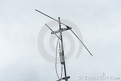 An outdoor access point attached on a traditional television antenna mounted on a roof. Overcast weather Stock Photo
