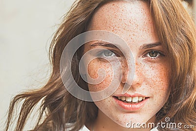 Outdoor beauty. Portrait of smiling young and happy woman with freckles. Stock Photo