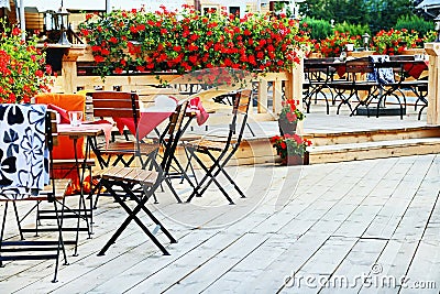 Outdoor cafe. Chairs and tables on the terrace with flowers. Stock Photo