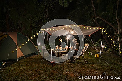 Outdoor camping tent with tarp or flysheet and Tent lighting, camping tent in the forest under night sky Stock Photo